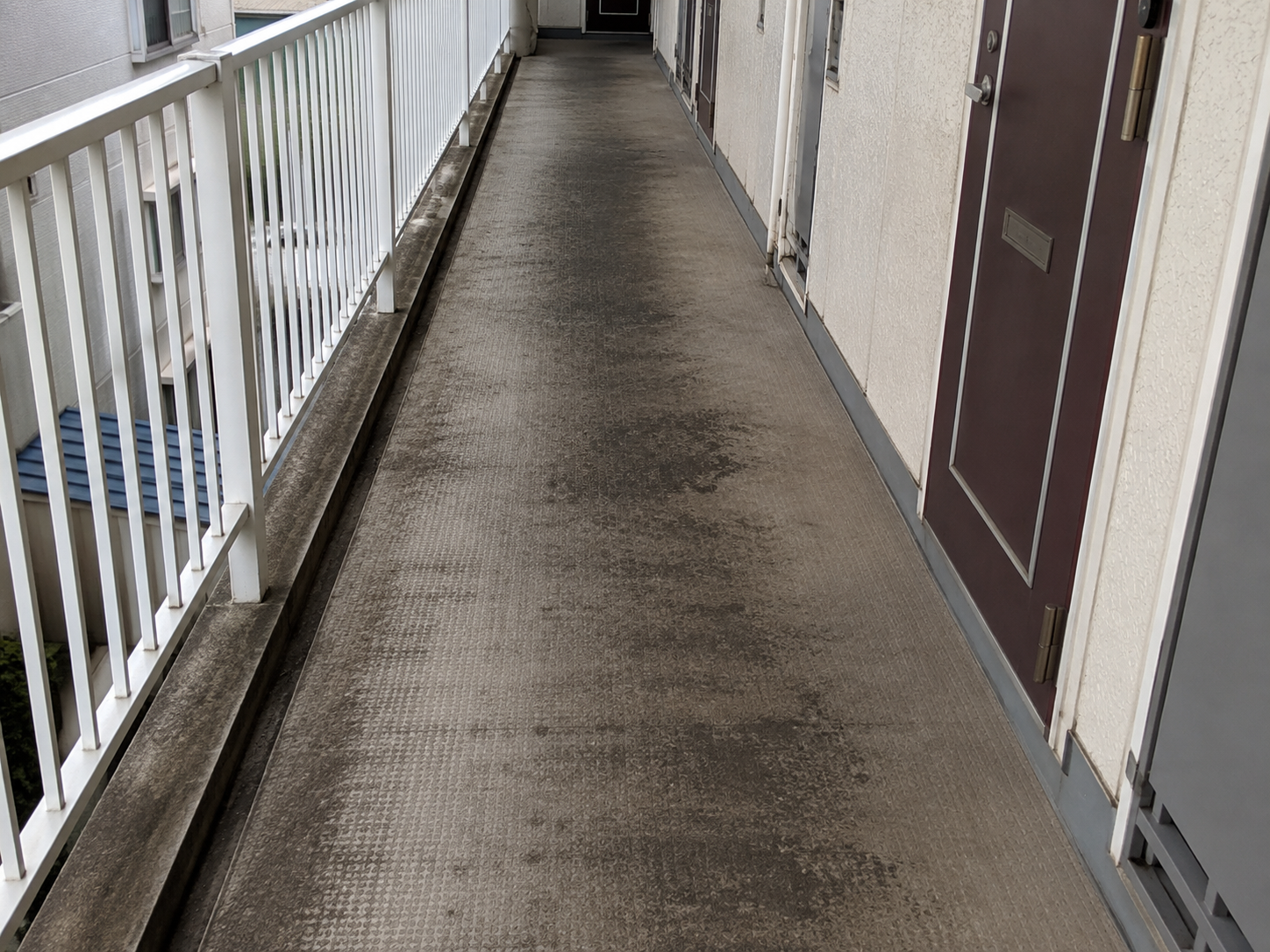 共用廊下に歩行跡や黒ずみが蓄積した洗浄前のイメージ