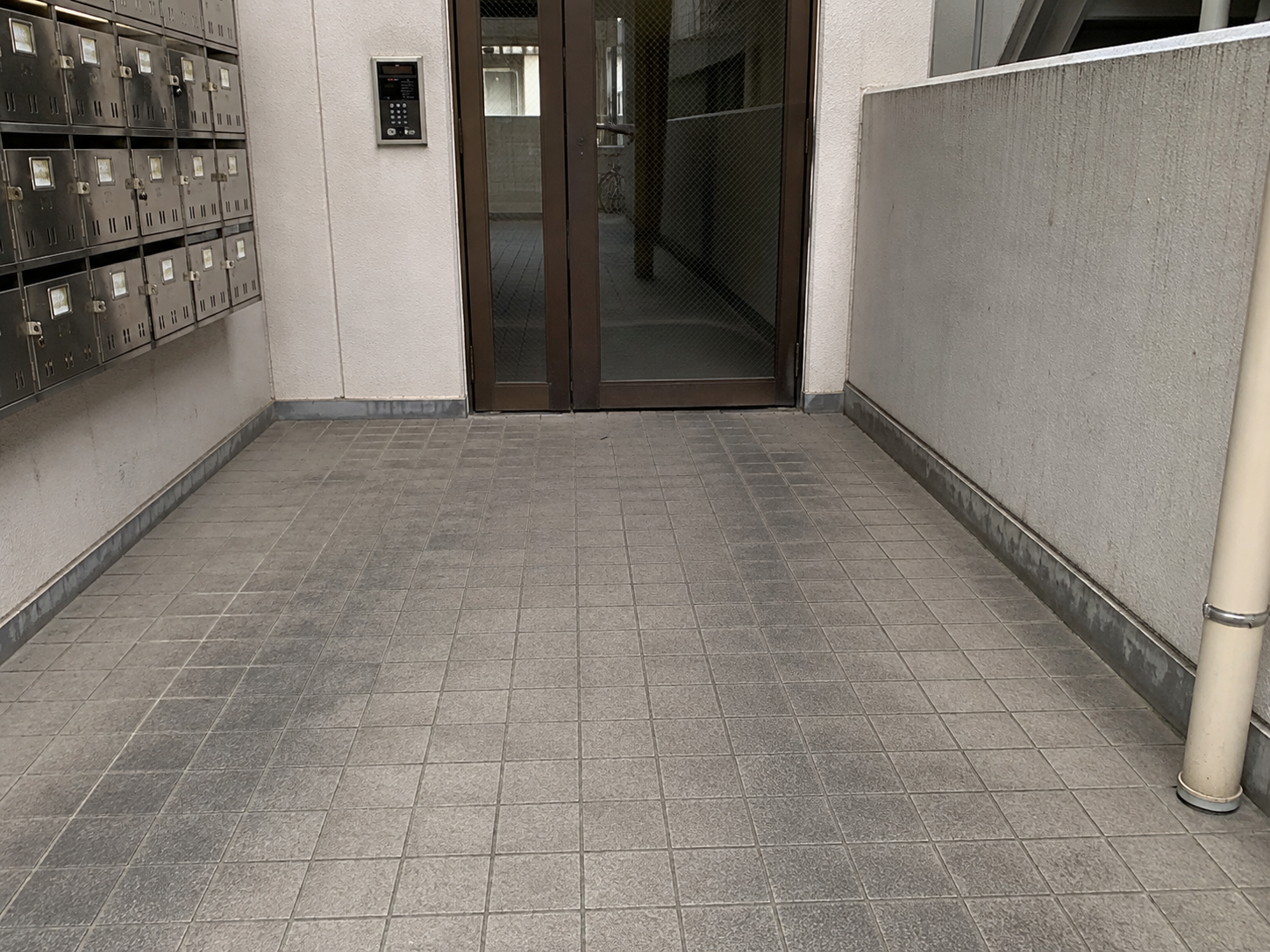 エントランス床に黒ずみやくすみが蓄積した洗浄前のイメージ