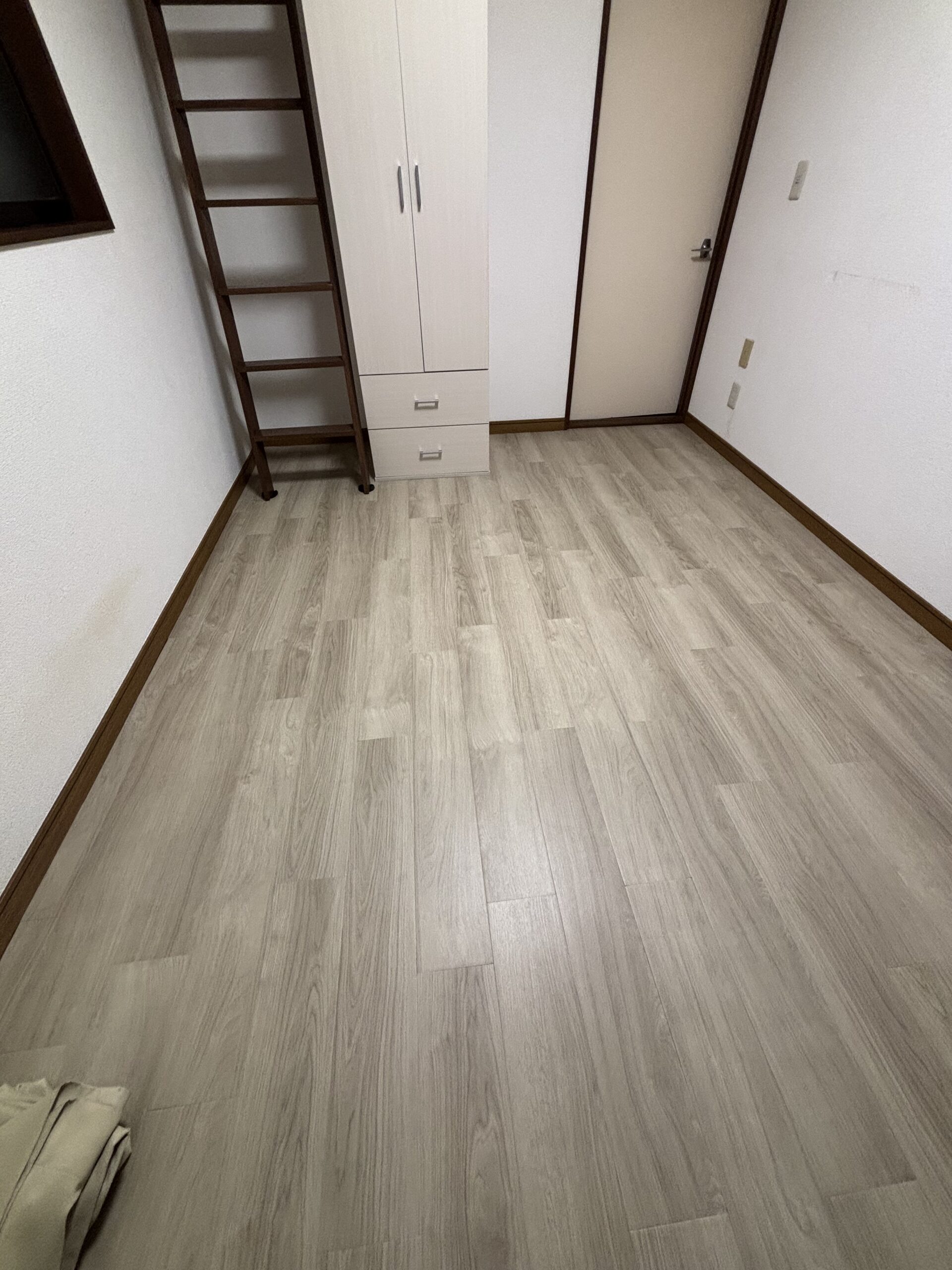 施工後の入口側。収納と出入口の前まで木目柄のフロアタイルで仕上げた床