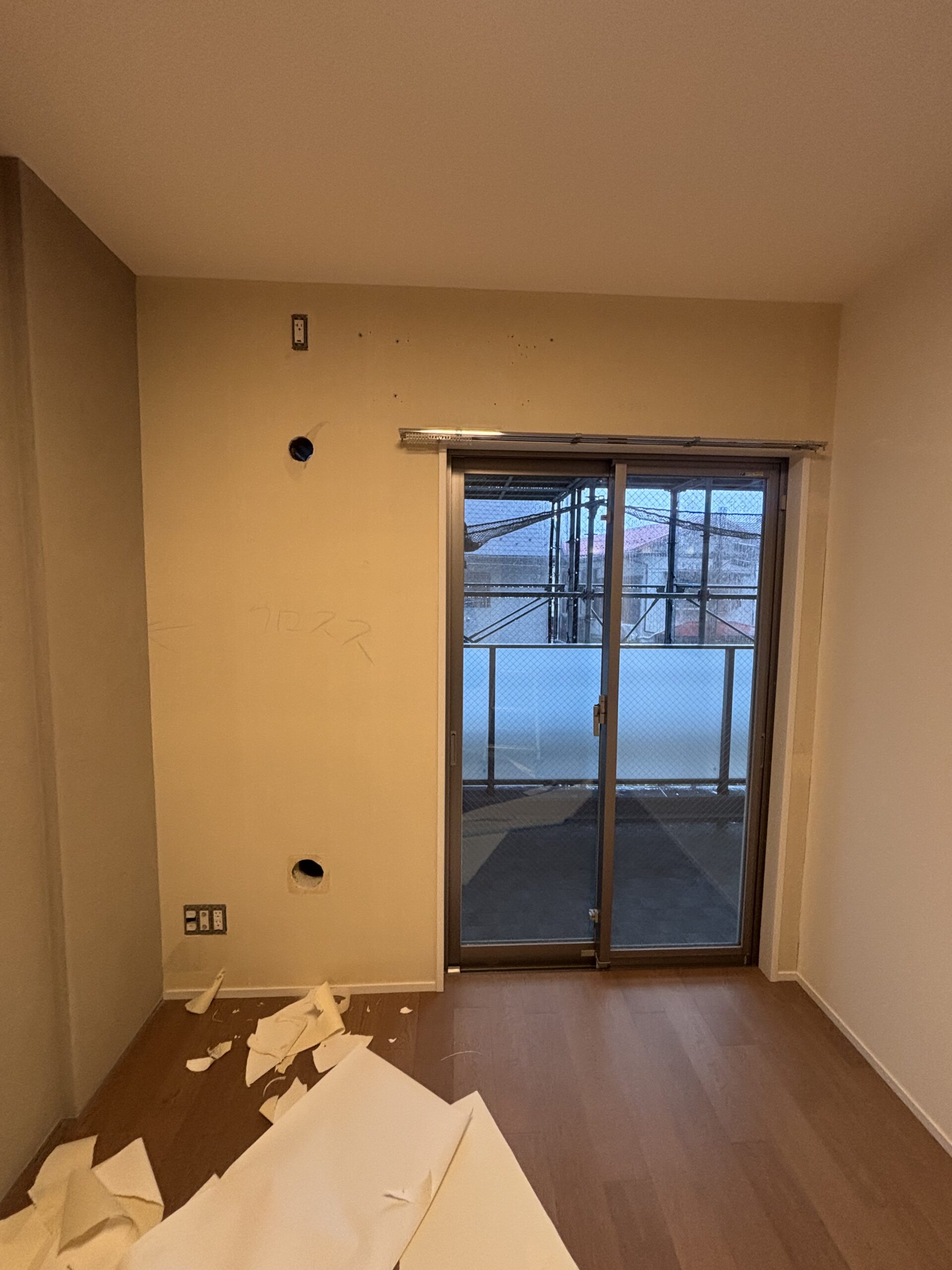 掃き出し窓のある壁一面の古いクロスを剥がした作業中の状態